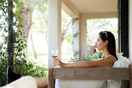 simsearch:632-08993453,k - Woman relaxing on veranda with glass of wine Stock Photo - Premium Royalty-Free, Code: 633-08639107
