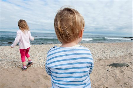 simsearch:632-03652319,k - Children at the beach, looking at ocean view Fotografie stock - Premium Royalty-Free, Codice: 633-08639112