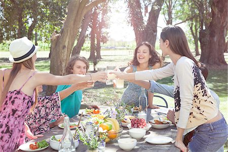 simsearch:633-08726159,k - Friends clinking glasses during outdoor meal at park Stock Photo - Premium Royalty-Free, Code: 633-08726156