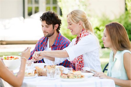 eating in chair side view - Friends having meal together outdoors Stock Photo - Premium Royalty-Free, Code: 633-08726237