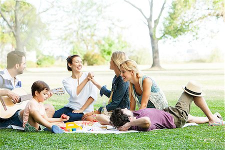 people sitting playing a guitar - Friends having lighthearted moment while picnicking in park Stock Photo - Premium Royalty-Free, Code: 633-08726260