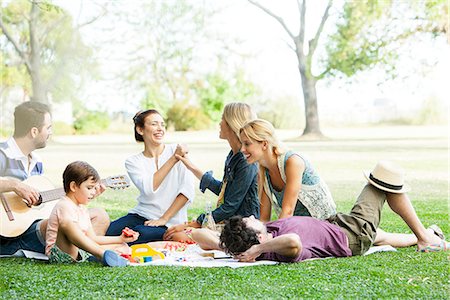 playing string instruments - Friends having lighthearted moment while picnicking in park Stock Photo - Premium Royalty-Free, Code: 633-08726260