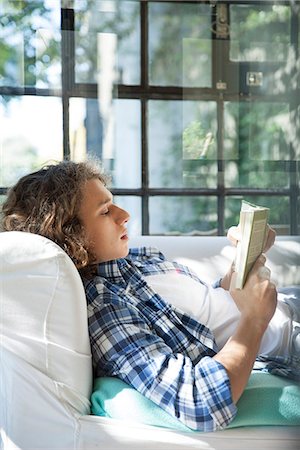 simsearch:633-03194783,k - Young man reading book on couch Stock Photo - Premium Royalty-Free, Code: 633-08726270