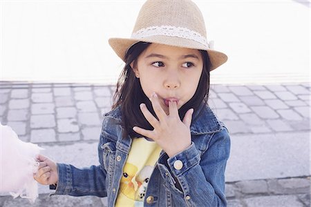 simsearch:632-03898066,k - Girl eating cotton candy, licking fingers Photographie de stock - Premium Libres de Droits, Code: 633-08726383