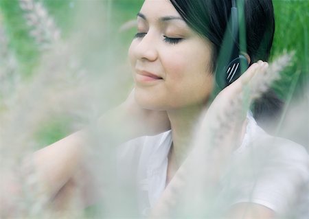 simsearch:633-02128680,k - Woman listening to headphones, vegetation in foreground Stock Photo - Premium Royalty-Free, Code: 633-01274010