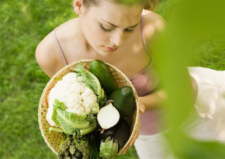 simsearch:633-01272776,k - Young woman holding up basket full of vegetables Foto de stock - Royalty Free Premium, Número: 633-01274165