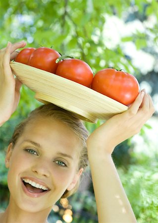 simsearch:633-01272776,k - Woman holding bowl full of tomatoes on top of head Foto de stock - Royalty Free Premium, Número: 633-01274199