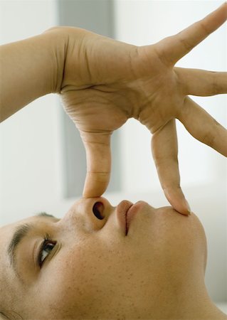 simsearch:632-03651843,k - Woman with fingers on nose and chin Stock Photo - Premium Royalty-Free, Code: 633-01274366