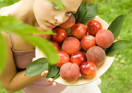 simsearch:633-01272776,k - Young woman holding up bowl of peaches and nectarines Foto de stock - Royalty Free Premium, Número: 633-01274482