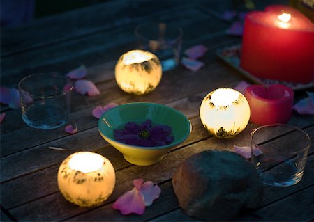 Candles glowing on table decorated with rose petals, and bowl holding floating flower Foto de stock - Sin royalties Premium, Código: 633-01274566