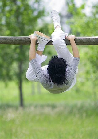 Young woman hanging on horizontal bar Stock Photo - Premium Royalty-Free, Code: 633-01274624