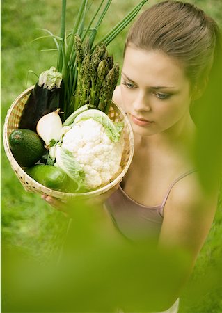 simsearch:633-01272776,k - Young woman holding up basket full of vegetables Foto de stock - Royalty Free Premium, Número: 633-01274680