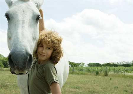 simsearch:633-01272720,k - Boy standing with arm around horse Stock Photo - Premium Royalty-Free, Code: 633-01274702