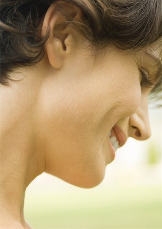 simsearch:695-03388489,k - Woman smiling and looking down, close up side view of face Stock Photo - Premium Royalty-Free, Code: 633-01274789