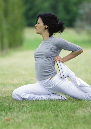 simsearch:695-03373919,k - Young woman stretching on grass Stock Photo - Premium Royalty-Free, Code: 633-01274902