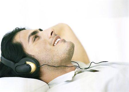 Man lying down, listening to headphones Foto de stock - Sin royalties Premium, Código: 633-01274986