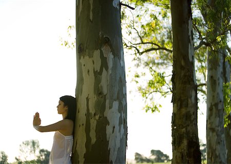 simsearch:6113-08220538,k - Frau stehend mit den Händen in Position, Gebet, an den Baum gelehnt Stockbilder - Premium RF Lizenzfrei, Bildnummer: 633-01274982