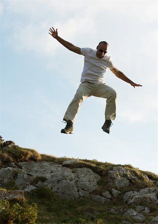 Man jumping in rocky landscape Stock Photo - Premium Royalty-Free, Code: 633-01275040