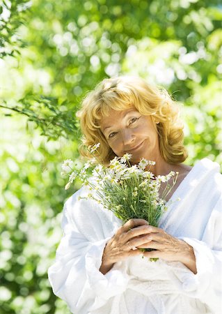 elderly woman beauty - Senior woman wearing bathrobe, holding flowers, outdoors Stock Photo - Premium Royalty-Free, Code: 633-01272141