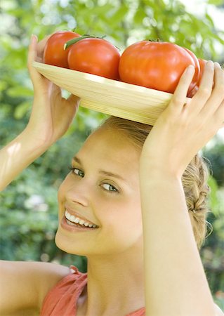 simsearch:633-01272776,k - Woman holding bowl full of tomatoes on top of head Foto de stock - Royalty Free Premium, Número: 633-01272188