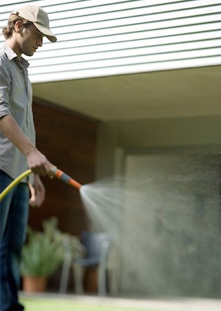 Gardener watering with hose Stock Photo - Premium Royalty-Free, Code: 633-01272285