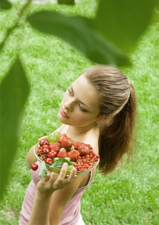 simsearch:633-01272776,k - Young woman holding up bowl of fruit Foto de stock - Royalty Free Premium, Número: 633-01272331