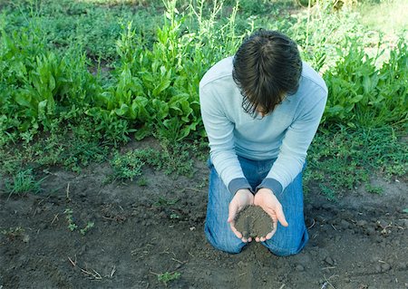simsearch:633-02231743,k - Man kneeling on ground, holding soil in hands Stock Photo - Premium Royalty-Free, Code: 633-01272345
