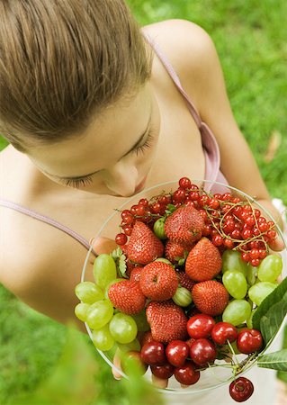 simsearch:633-01272776,k - Young woman holding up bowl of fruit Foto de stock - Royalty Free Premium, Número: 633-01272645