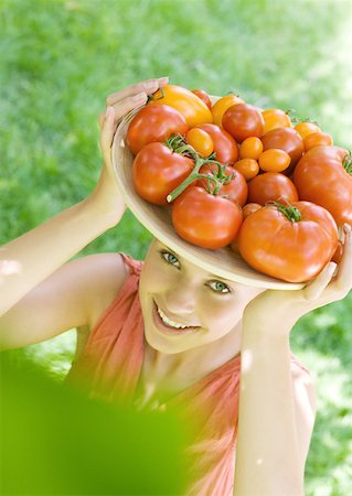 simsearch:633-01272776,k - Woman holding bowl full of tomatoes on top of head Foto de stock - Royalty Free Premium, Número: 633-01272776