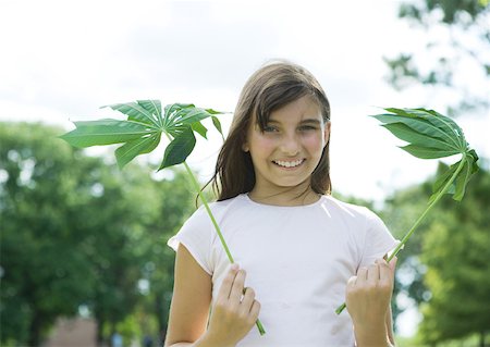 Girl standing holding cassava leaves Fotografie stock - Premium Royalty-Free, Codice: 633-01272818