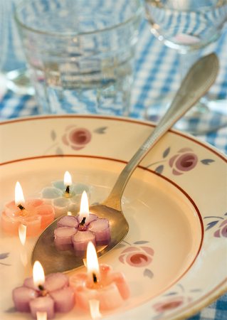 simsearch:633-01274235,k - Lit flower-shaped candles in soup plate, with spoon Stock Photo - Premium Royalty-Free, Code: 633-01273255