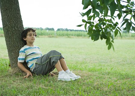 sitting under tree - Garçon assis sur le sol, appuyé contre le tronc d'arbre Photographie de stock - Premium Libres de Droits, Code: 633-01273318