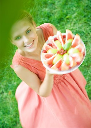 simsearch:633-01272776,k - Woman holding up plate of fruit slices Foto de stock - Royalty Free Premium, Número: 633-01273311