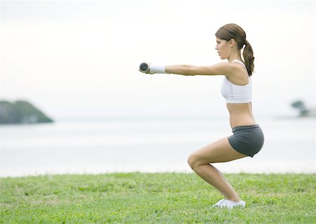 squats dumbbells - Young woman working out with weights, outdoors Stock Photo - Premium Royalty-Free, Code: 633-01273347