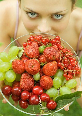 Woman holding bowl of fruit, smiling at camera Stock Photo - Premium Royalty-Free, Code: 633-01273447