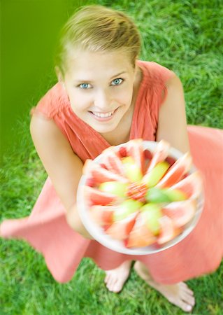 simsearch:633-01272776,k - Woman holding up plate full of fruit slices and spinning around, high angle view Foto de stock - Royalty Free Premium, Número: 633-01273574