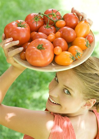 simsearch:633-01713992,k - Woman holding bowl full of tomatoes on top of head Foto de stock - Sin royalties Premium, Código: 633-01273846