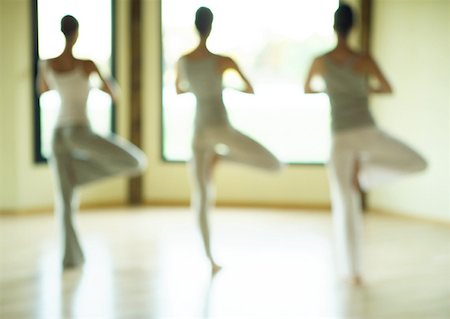 Yoga class standing in tree pose, defocused Stock Photo - Premium Royalty-Free, Code: 633-01273849