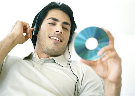 Man listening to headphones, looking at CD Foto de stock - Sin royalties Premium, Código: 633-01273903