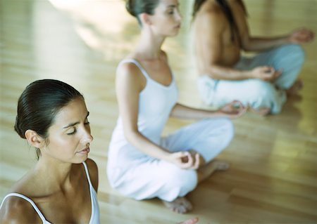 simsearch:632-03651843,k - Yoga class sitting in lotus position Stock Photo - Premium Royalty-Free, Code: 633-01273968