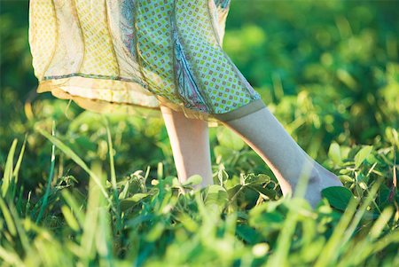 simsearch:633-01992711,k - Young woman wearing long dress walking across grass, close-up, knee down Stock Photo - Premium Royalty-Free, Code: 633-01574145