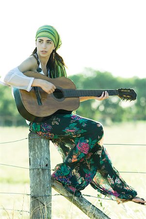 simsearch:633-01715215,k - Femme jeune hippie assis sur le poteau de clôture, jouer de la guitare Photographie de stock - Premium Libres de Droits, Code: 633-01574149
