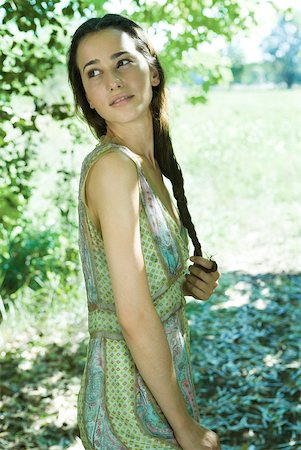 Young woman wearing dress, twirling hair, looking over shoulder, portrait Foto de stock - Sin royalties Premium, Código: 633-01574168