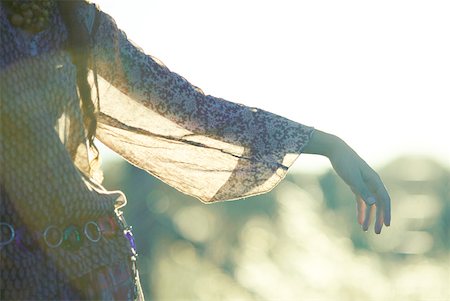 Young woman wearing translucent blouse, holding out arm, cropped view Stock Photo - Premium Royalty-Free, Code: 633-01574178