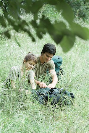 simsearch:633-01715609,k - Hiking couple opening backpack in grass Stock Photo - Premium Royalty-Free, Code: 633-01574452