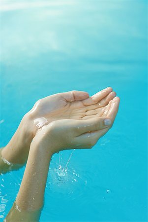 Young woman's hands cupping water Stock Photo - Premium Royalty-Free, Code: 633-01574489