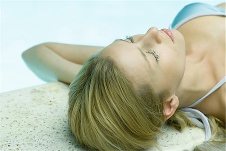 simsearch:633-01573942,k - Young woman lying by edge of pool, eyes closed Stock Photo - Premium Royalty-Free, Code: 633-01574531