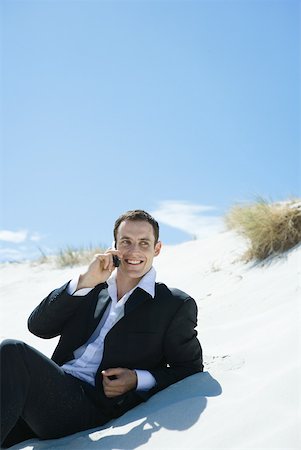 simsearch:633-01574593,k - Businessman sitting on dune, using cell phone Stock Photo - Premium Royalty-Free, Code: 633-01574592