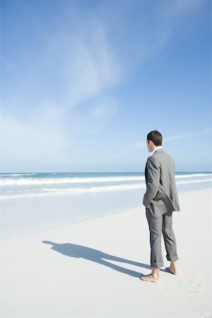 simsearch:633-03194783,k - Barefoot businessman standing on beach, facing ocean Stock Photo - Premium Royalty-Free, Code: 633-01574605