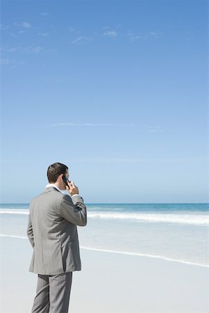 simsearch:633-01574593,k - Businessman standing on beach, using cell phone Stock Photo - Premium Royalty-Free, Code: 633-01574613